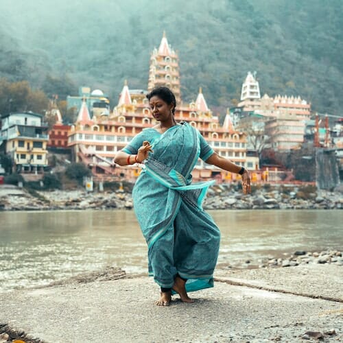 A woman in a blue sari dancing in front of a temple for WhatsApp Sad Girl DP.